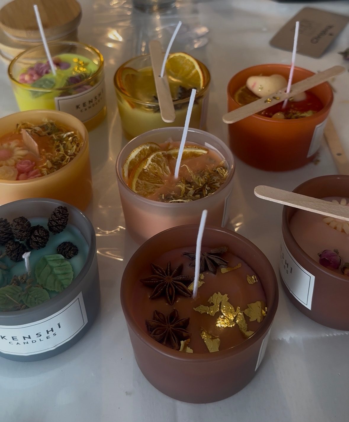 Teilnehmerin zeigt ihre selbst gegossene Duftkerze mit Rosenblüte