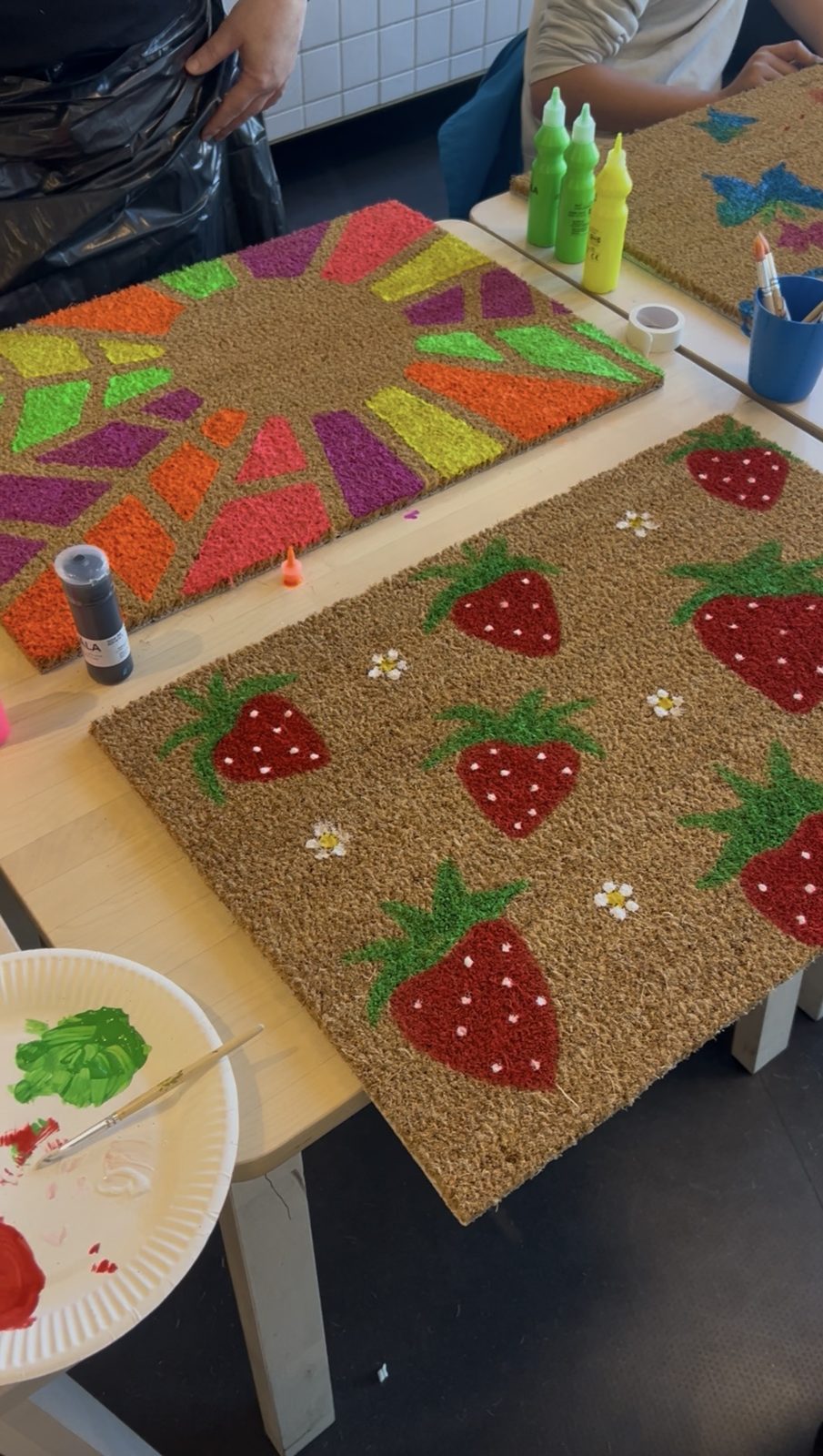 Kokosmatten mit Erdbeeren und bunten Strahlen entstehen am Workshop-Tisch – Fußmatte bemalen in Kaarst