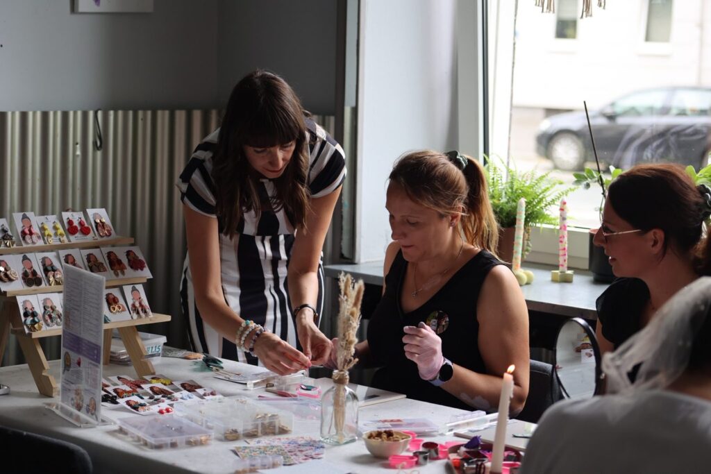 Tündi erklärt am Workshop-Tisch die Gestaltung der Polymer Clay Ohrringe – Atelier Wundervoll Kaarst