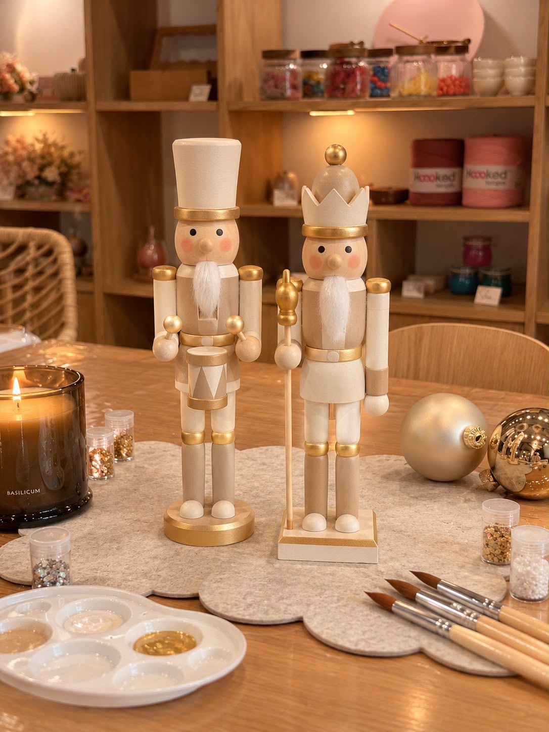 Selbst bemalte Nussknacker in Creme und Gold mit Fellbart am Workshop-Tisch – Nussknacker bemalen im Atelier Wundervoll Kaarst