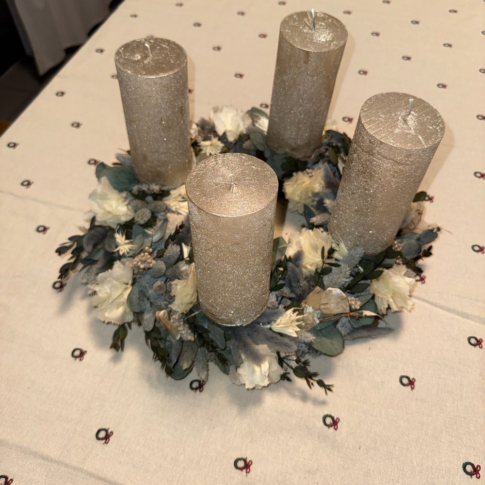 Adventskranz aus Trockenblumen mit vier goldenen Kerzen