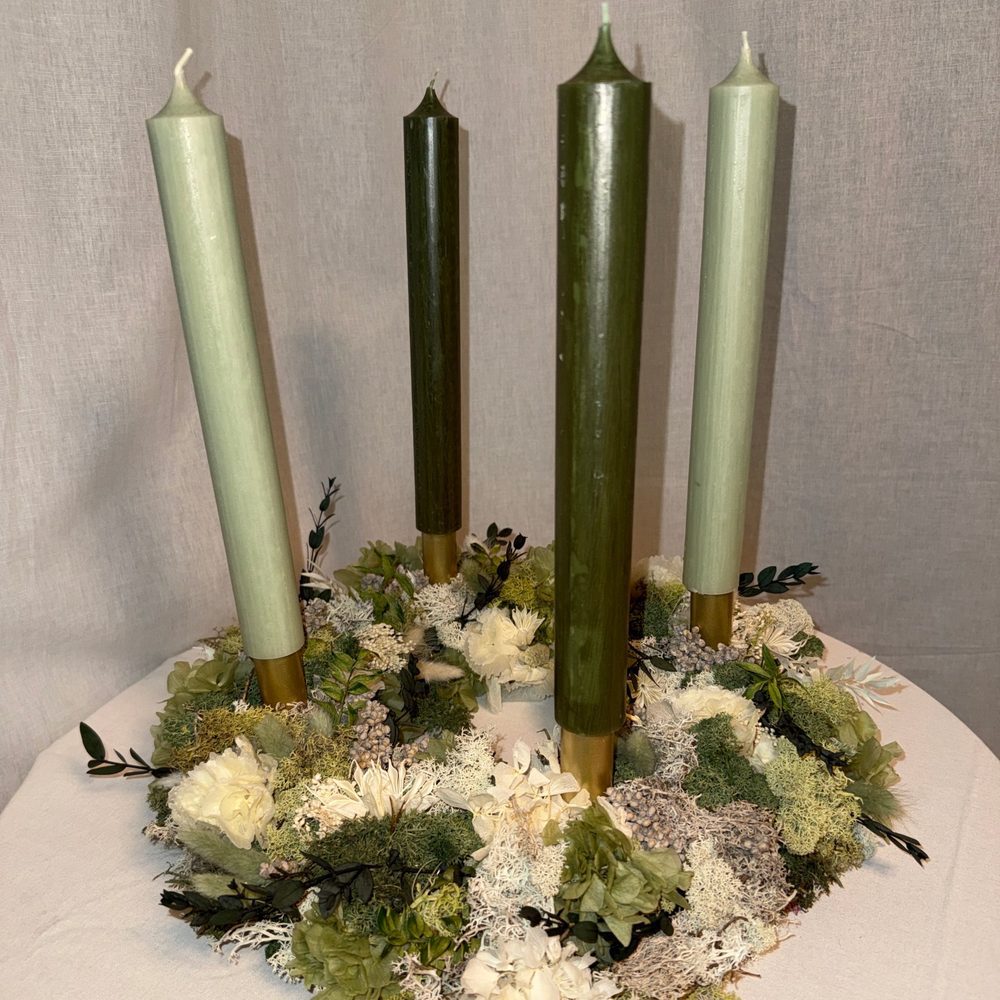 Adventskranz aus Trockenblumen mit vier grünen Stabkerzen