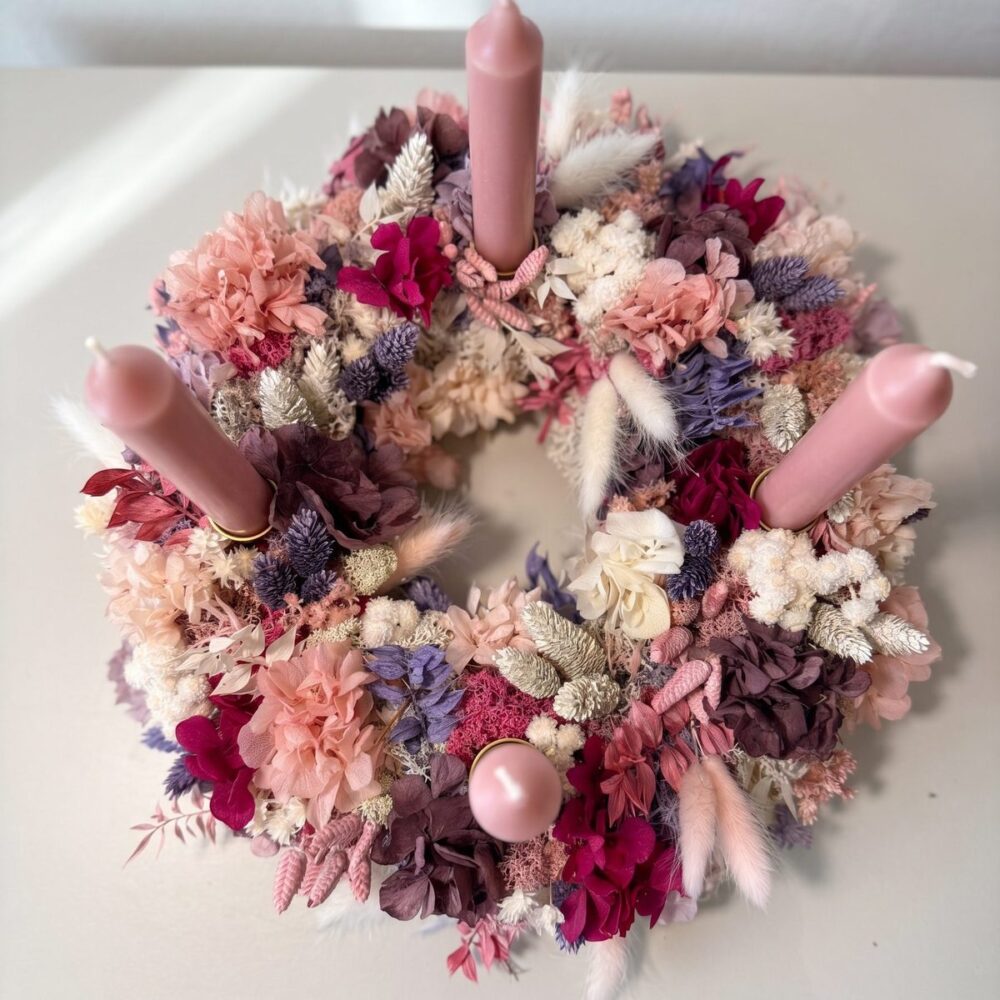 Adventskranz aus Trockenblumen mit vier rosa Kerzen