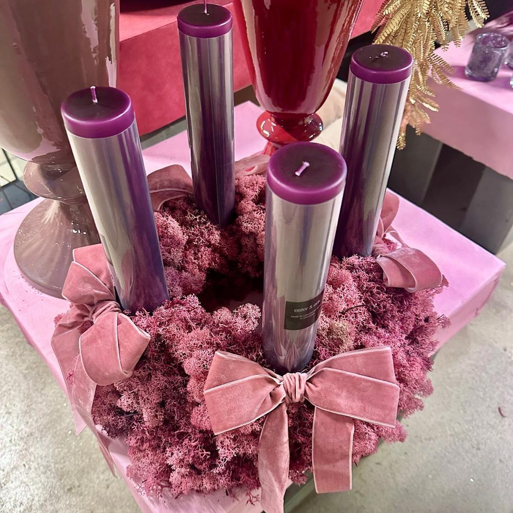 Adventskranz aus rosa Islandmoos mit vier lila Kerzen und Samtschleifen bei Selders